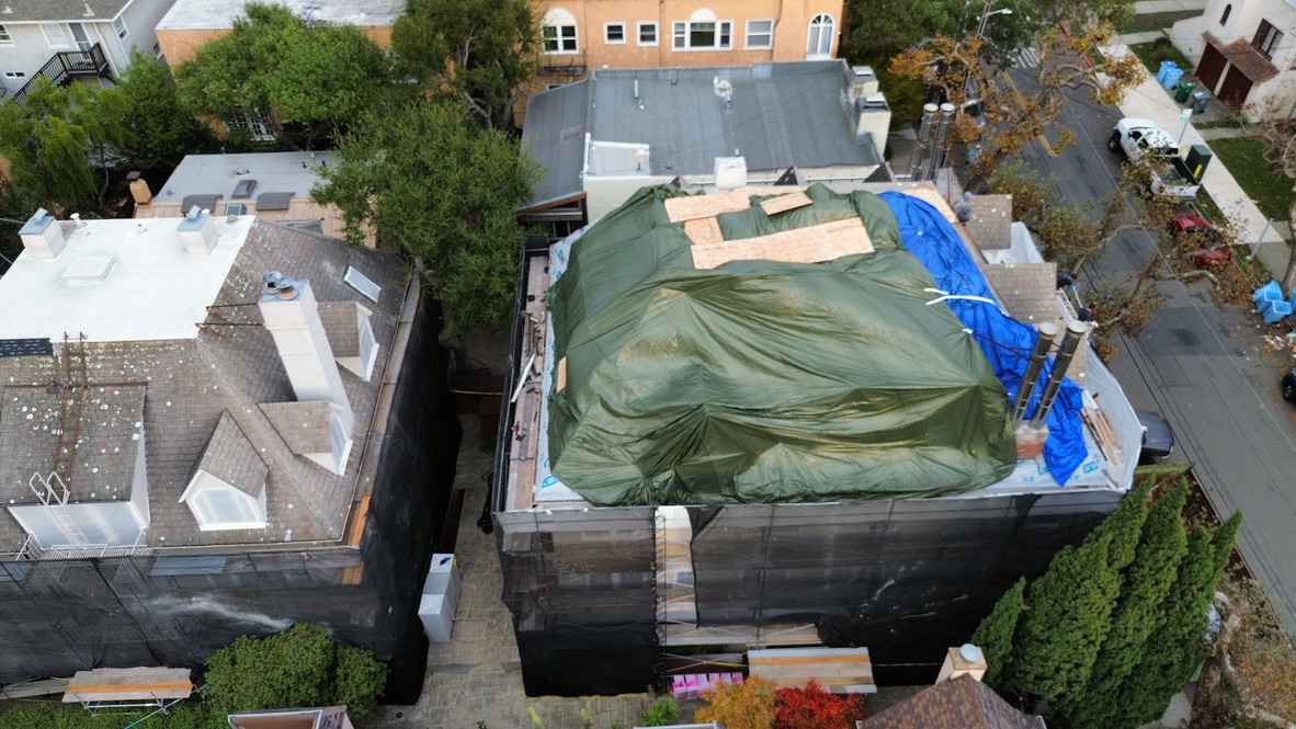 Golden Heights Roofing - Aerial view of a Bay Area home roof protected with heavy-duty storm tarps during a roof replacement