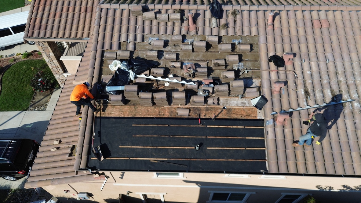Tile roof installation in progress showing precision underlayment and batten work
